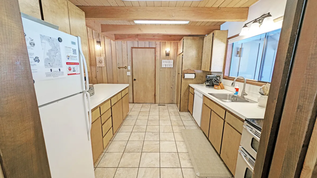 A well-appointed kitchen with wooden cabinetry, spacious countertops, and modern appliances. The kitchen exudes a cozy, functional vibe and is clearly designed for hosting and preparing meals together, reflecting the heart of home-cooked gatherings.